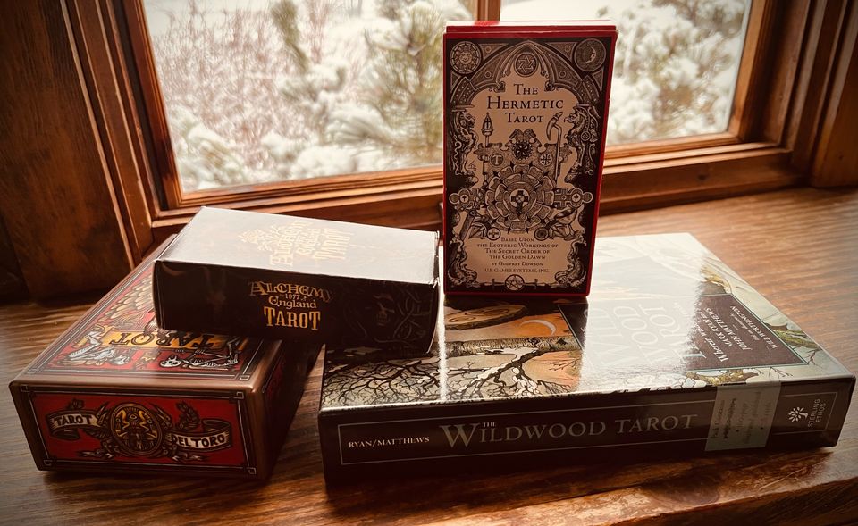 Four decks of tarot cards: the Tarot Del Toro, Alchemy of England Tarot, the Hermetic Tarot, and the Wildwood Tarot.